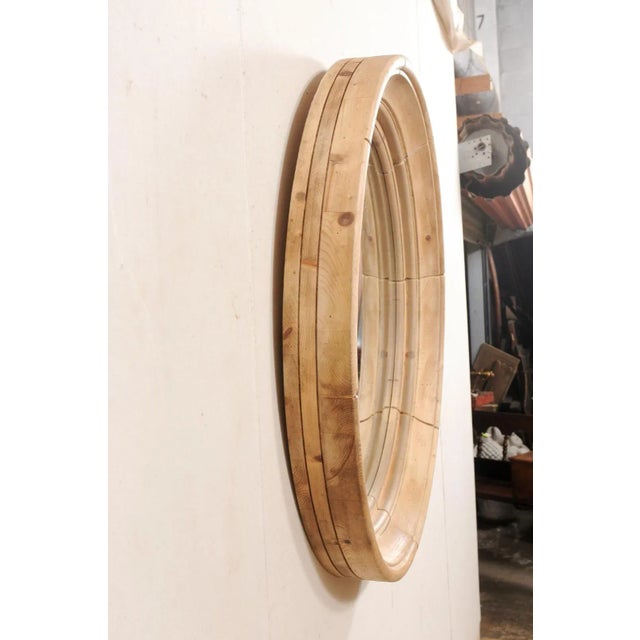 A vintage English round mirror with bleached wood surround. This mirror from England features a circular-shaped mirror,...