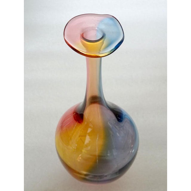 A Fidji bottle designed in the 1980s by Kjell Engman for the brand Kosta Boda. Fluted glass in yellow, blue, and pink...