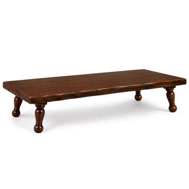 A striking handcrafted rustic table set featuring one substantial low-slung coffee table and a matching pair of...