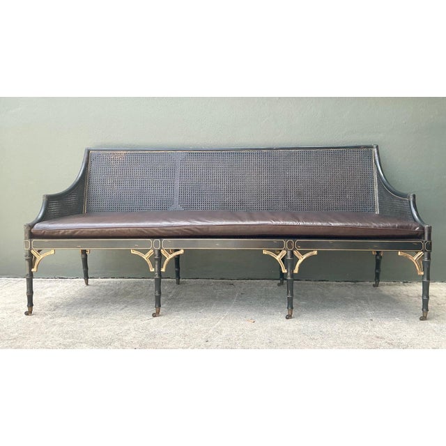This elegant vintage cane settee presents a refined blend of materials and craftsmanship evocative of early 20th-century...