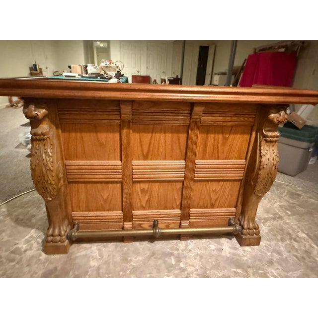 Vintage Pulaski Keepsake Collection Oak Wood Bar with carved Griffins, brass top and brass foot rail. Three oak doors with...