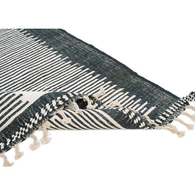 Modern flatweave rug featuring a central Ivory stripe bordered by deep Charcoal Black bands with intricate line patterns....