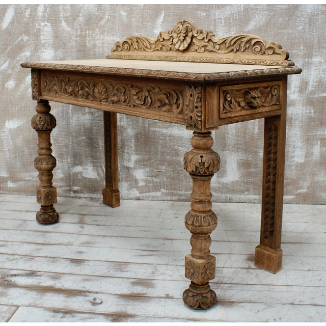 A Superb Oak Hall Table. Made from English Oak, with heavy hand carving to the top, sides and down the bulbous hand turned...