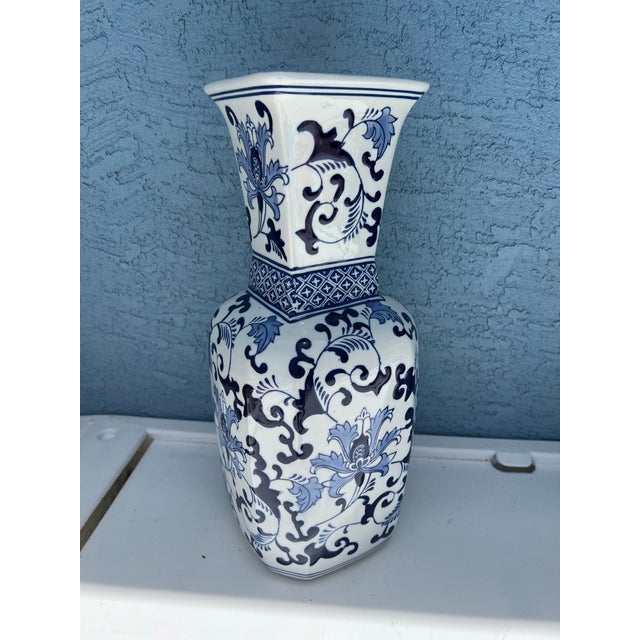 Large blue & White Floral vase. Stands 16” tall with a flared neck and square rim at 5” diameter.