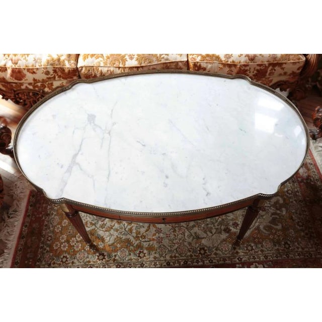 Coffee table from the 1950s, a very special model with a Carrara marble top, the top is bordered by a fine brass border,...