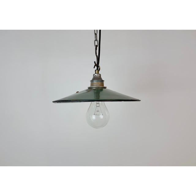 Vintage industrial enamel pendant lamp from the 1950s. It features a green enamel shade with white enamel interior and a...