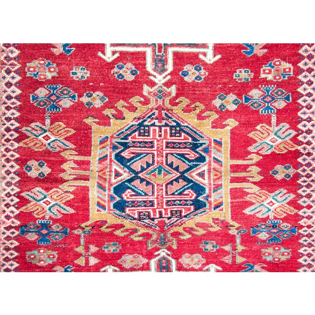 A striking early 20th century Persian Karaja rug with a tribal pattern containing three large central medallions heavily...