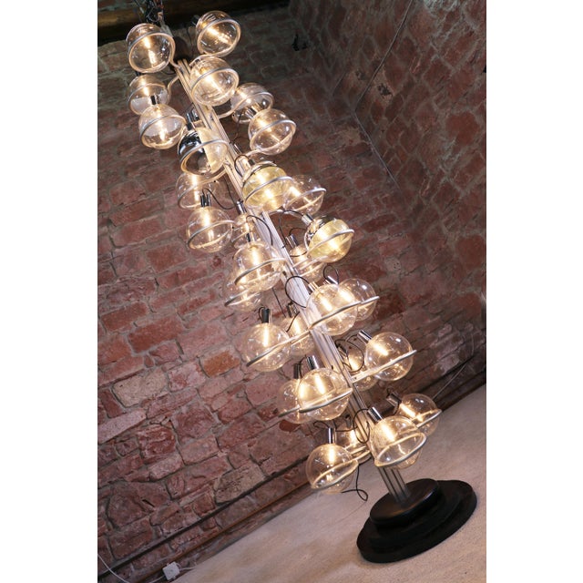 This floor lamp features 32 glass globes supported by metal rings. The globes are arranged in eight rows and are fixed on...