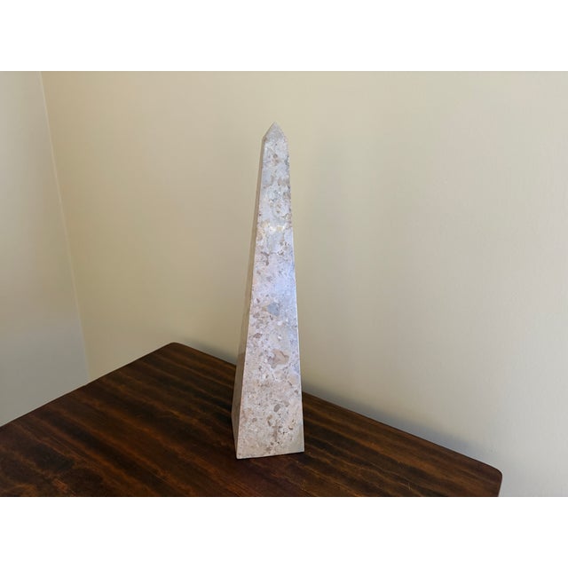 A beautifully proportioned marble obelisk in richly veined shades of brown, cream, and grey. The sculptural silhouette and...