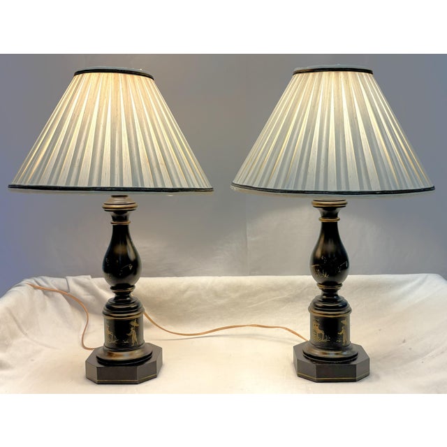 Great pair of vintage wood table lamps from the late 20th century. These have an ebony finish with delicately painted in...