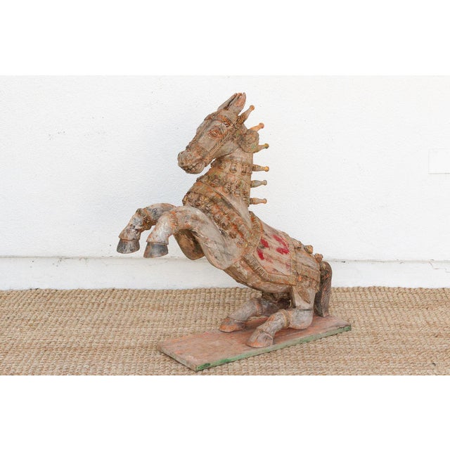 A magnificent antique finely carved ceremonial horse, commanding attention at 39 inches long and 39 inches high. This...
