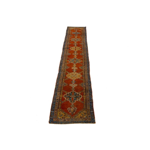 This Bakshaeish Persian hand-knotted rug showcases a striking orange rust field enhanced by multicolored accents,...