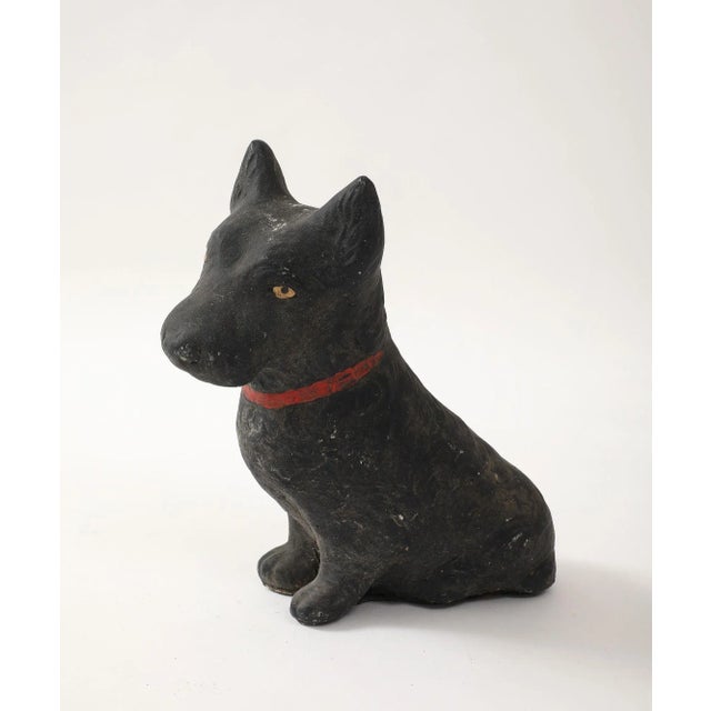 Unique reconstituted stone garden statue in the shape of a black painted Scottie dog with red paint collar, and amber...