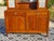 A two-door, two-drawer sideboard surmounted by two small cabinets framing a mirror. The glass-fronted cabinets feature...