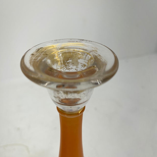 Art Deco orange and black pressed glass candlesticks in the manner of Charles Schneider. The candle holders have a...