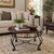 A handsome vintage round coffee table pairing a warm, richly toned wood top with an elegant black metal scrollwork base....