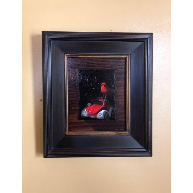 This artwork features a vibrant red cardinal perched atop a toy ambulance, framed by a rustic wooden structure that adds...