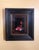 This artwork features a vibrant red cardinal perched atop a toy ambulance, framed by a rustic wooden structure that adds...