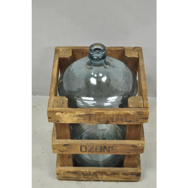 Vintage Great Bear Blue 5 Gallon Glass Carboy Jug in Wooden Crate. Circa Mid 20th Century. Measurements: 20" H x 12" W x...