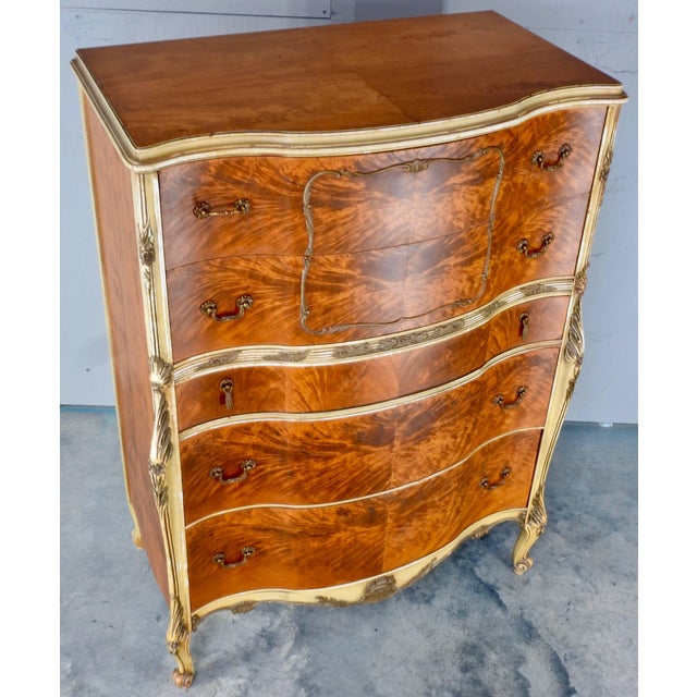 Elegant satinwood makes up this ornate chest on chest from France in the early 20th Century. Wood trim painted gold adds...