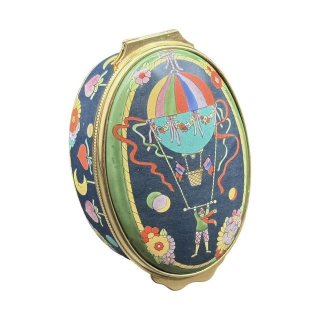 A whimsical and rare enamel trinket box produced by Halcyon Days for Gucci, circa 1988, made in England. The oval egg-form...