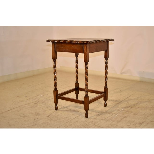 Circa 1900 Edwardian oak side table from England. The top has a scalloped and beveled edge surrounding a wonderfully...