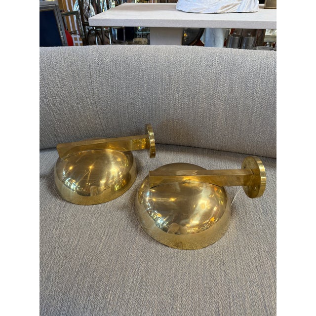 A refined pair of Italian wall sconces from the 1970s, crafted entirely in brass and defined by their sculptural, semi-...