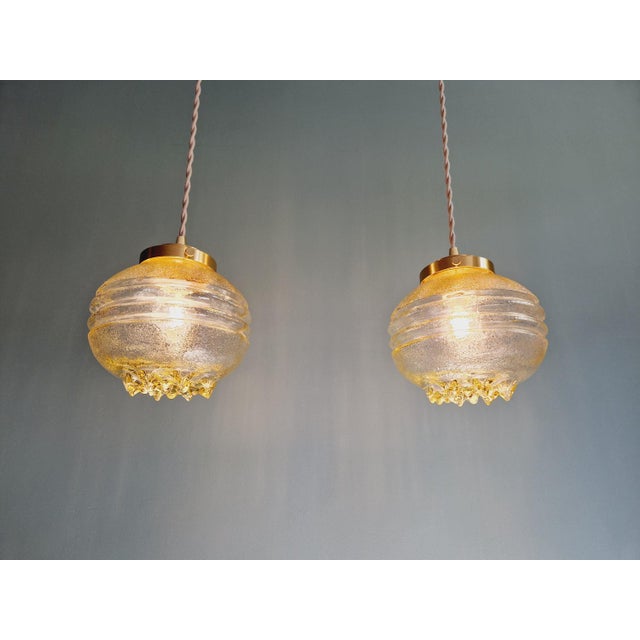 Space Age pendant light in yellow transparent glass from the 60s and 70s. --> 13 pieces available Each of the pendant...