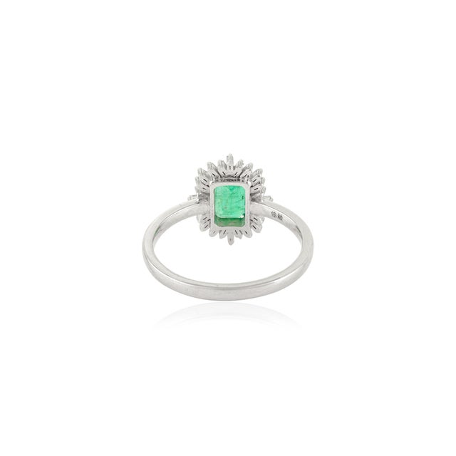 Exuding timeless elegance, this exquisite ring is crafted in 14k white gold and showcases a vibrant 0.89 carat emerald-cut...