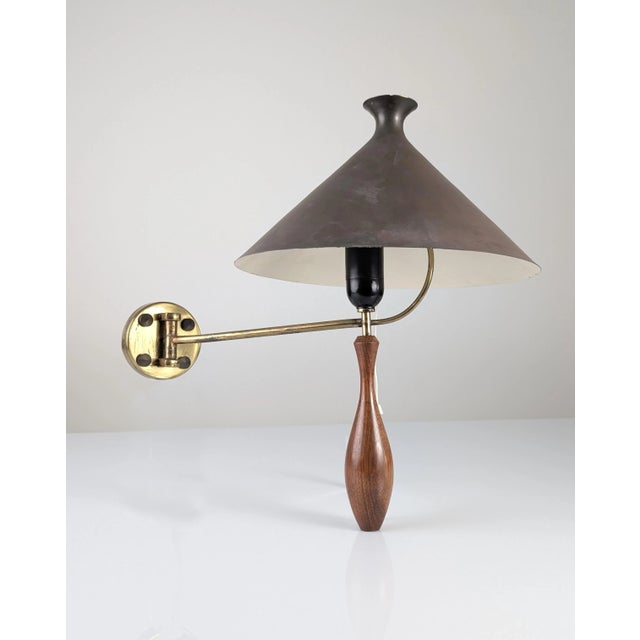 A 1950s wall sconce featuring an elegant, precision-turned, solid wood handle finished in a stylized teardrop shape. The...