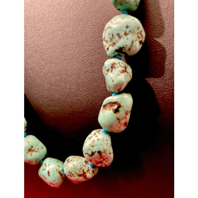 This turquoise nugget necklace features naturally shaped turquoise stones with a spiderweb matrix pattern, created in the...