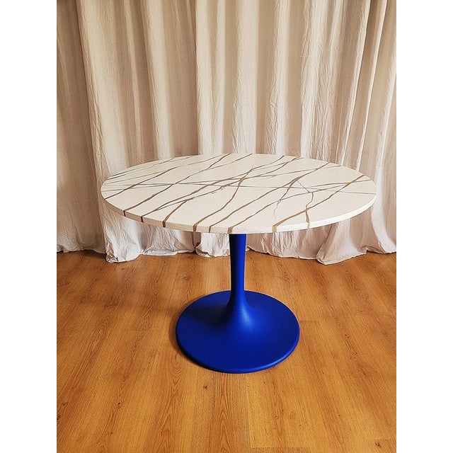 A table with a tulip leg, a classic in its form from the 1970s. A renovated dining table. The table top is covered with...