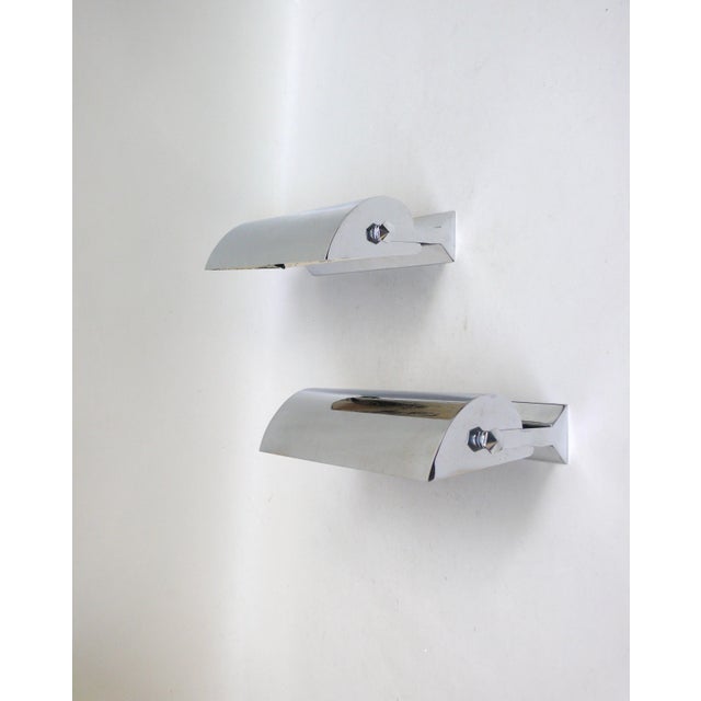 A pair of minimalist wall lights, made in France, in the typically austere style of Art Deco. The lights are crafted with...