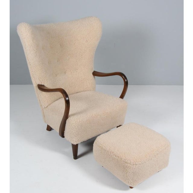 Alfred Christensen lounge chair with ottoman new upholstered with lamb wool. Legs and armrests of stained beech. Made in...