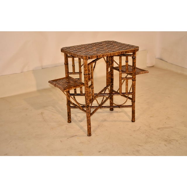Circa 1920 bamboo side table with side shelves from England. This is a lovely table with a lot of design impact. The top...