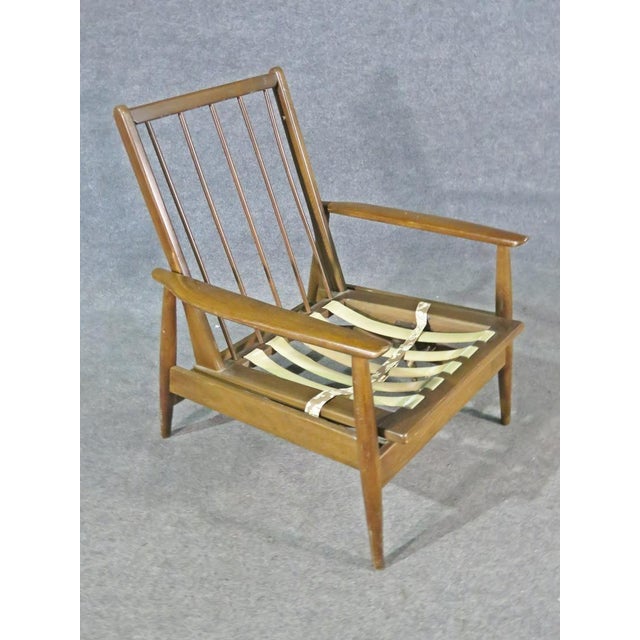 With rich walnut making up this chair's frame and spindle back, this vintage rocking chair is full of Mid-Century style.