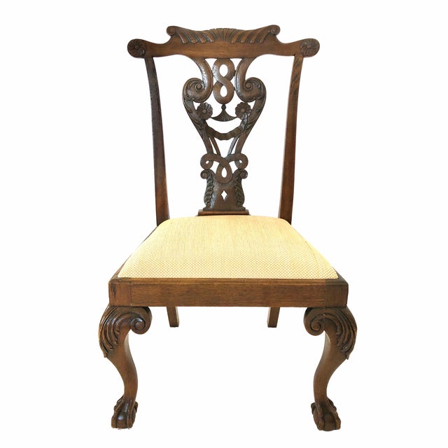 The chairs constructed in oak with shaped crests over open work splats. The trapezoidal seats over cabriole legs with claw...