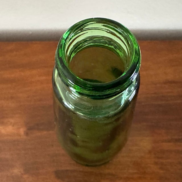 Green glass SCHWEPPES Bottle. Royal British Warrant Rampant lions embossed all the way around along the bottom. Two seams...