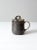 A vintage studio pottery lidded mug with hand-crafted ombré glaze transitioning from cream to charcoal. the softly...
