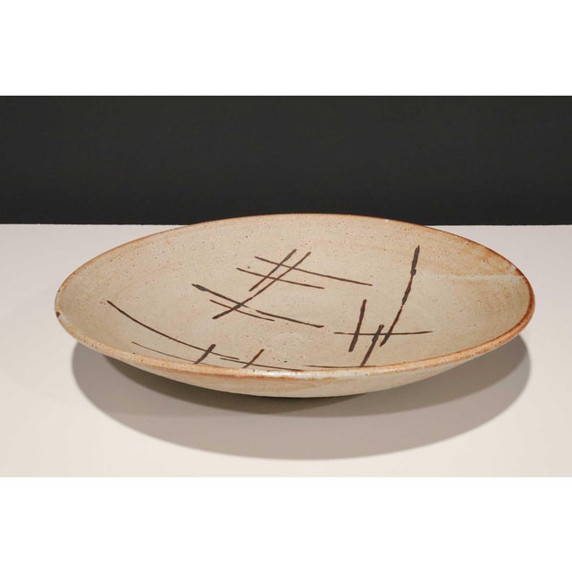Large studio pottery platter with brown decorative dashes. Warren MacKenzie is known for simple, wheel-thrown functional...