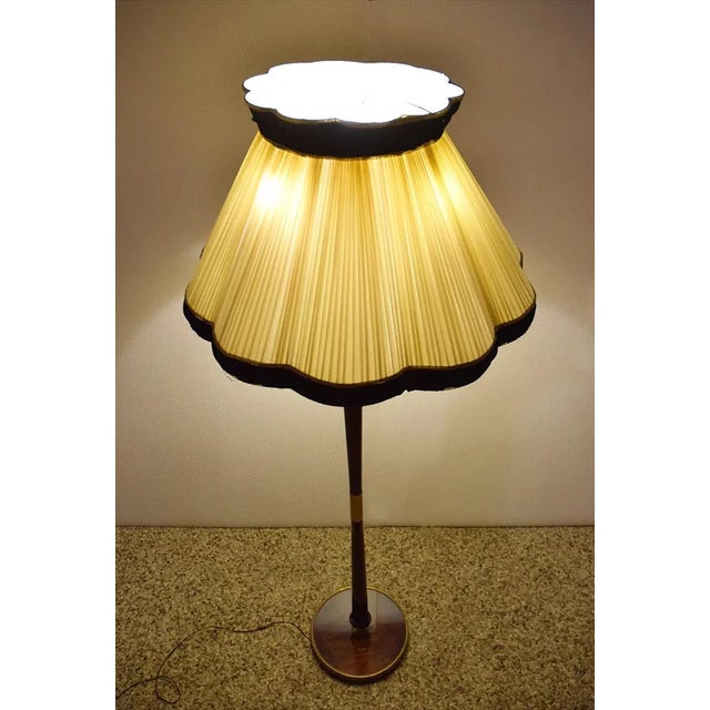 Mid-century Italian floor lamp, 1950s. Structure in mahogany wood with brass details, foot in mahogany with brass band and...