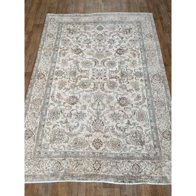 A regal vintage Tabriz. This Tabriz offers a tan palette with brown, beige, and green accents.