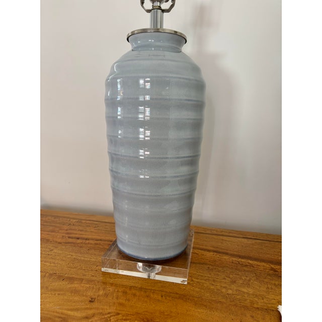 Handcrafted Port 68 table lamp features a crazed porcelain form in light dove gray on a rectangle lucite base. Accented...