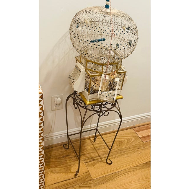 Antique handmade domed wire birdcage on stand with decoration.