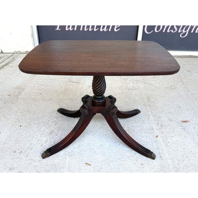 Early 20th Century mahogany accent table featuring a classic pedestal base with carved spiral column and claw feet....