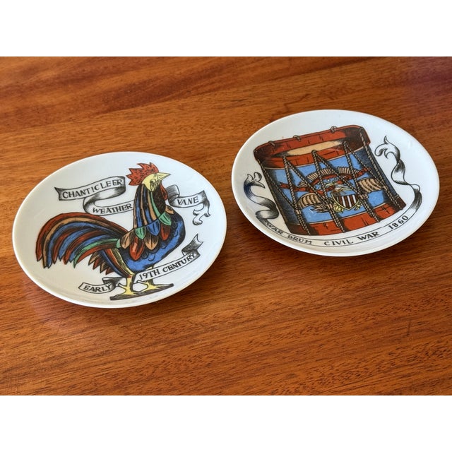 Charming pair of small decorative Americana ceramic coaster plates, featuring a Chanticleer weather vane and a war drum...