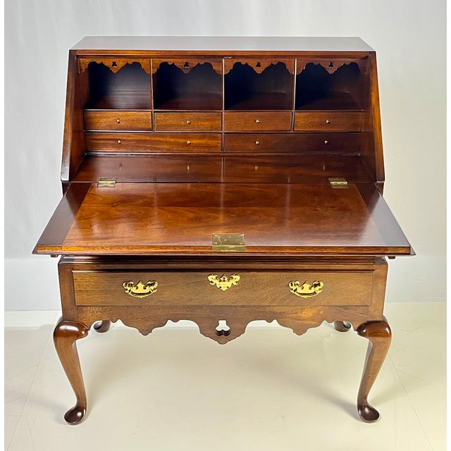 Queen Anne style mahogany slant-front bureau secretary desk on stand. This beautifully crafted two-part piece features a...