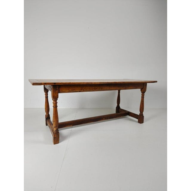 This antique early 19th-century French farmhouse dining table with rustic charm and timeless elegance. Crafted from solid...