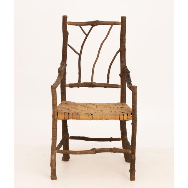 Adirondack Style Rustic Twig and Branch Arm Chair, with woven natural fiber seat. 40" H x 21.5" W x 17" D; seat: 17" H....