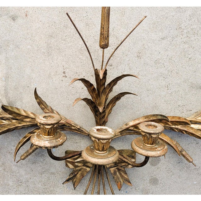 Hollywood Regency style brass wall sconce, specifically an Italian-designed 5-armed candelabra wall sconce. Crafted from...